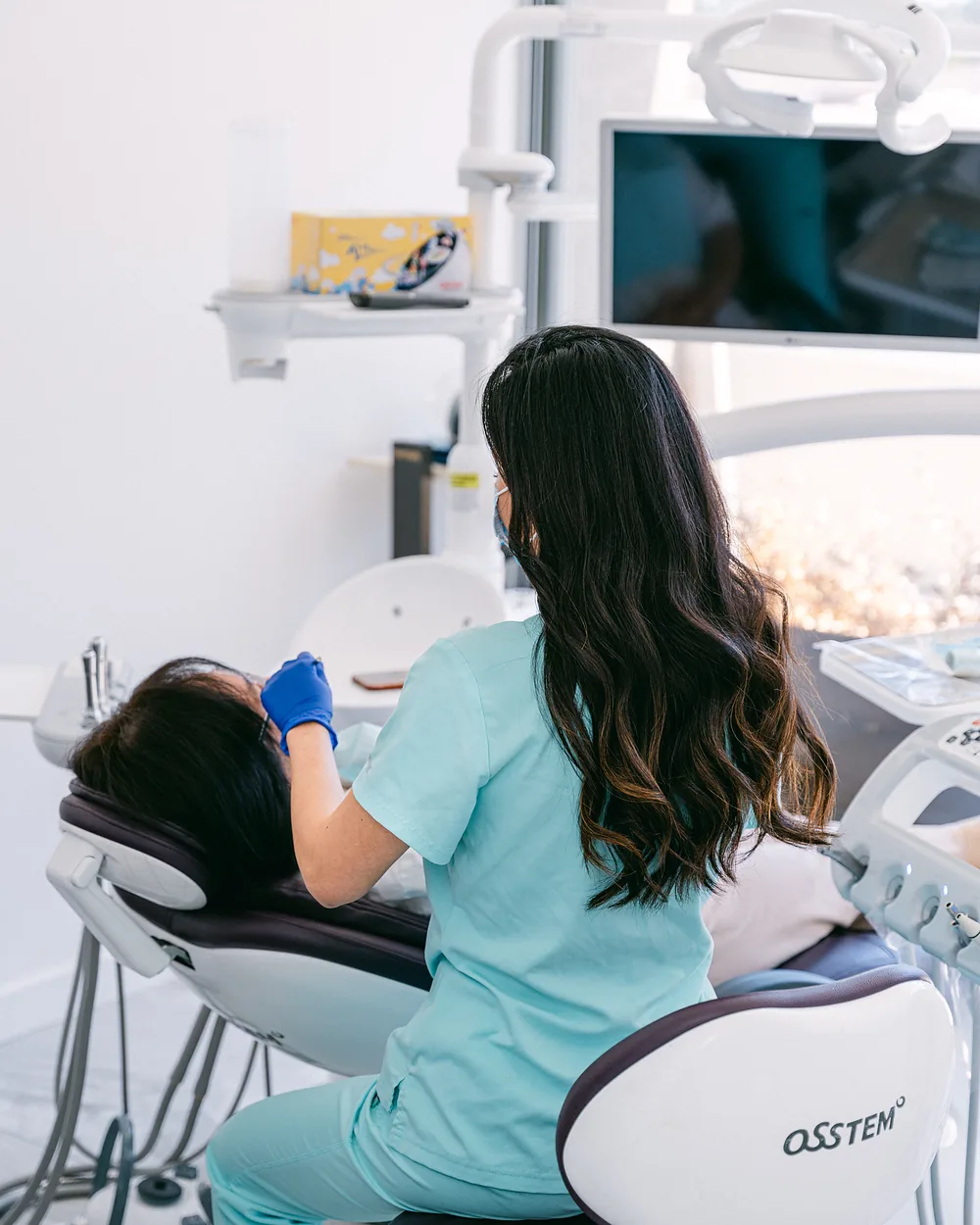 Dentist examining a relaxed patient in the treatment chair